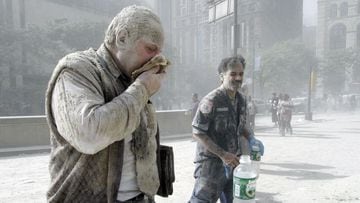 A man coated with dust and debris from the collapse of the World Trade Center south tower coughs near City Hall, in New York.