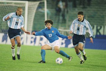 Retorno al Olímpico de Roma para celebrar un partido amistoso entre Argentina e Italia, un 28 de febrero. Una gran generación de futbolistas emergentes presentaba uno de los duelos de mayor calado a nivel de selecciones. La Albiceleste de Crespo o Simeone, encontraría en esta final a la Italia de Inzaghi. Este partido es uno de los últimos enfrentamientos que han jugado ambos equipos, dejando una gran sensación a los aficionados argentinos, que derrotaron en suelo italiano a la selección ‘Azzurra’. El partido terminó 1-2 a favor de la Albiceleste, con goles de Kily González y Hernán Crespos que sirvieron para remontar un partido en el que se adelantaron los locales por
medio de Stefano Fiore en el marcador. En la foto, Damiano Tommasi entre Juan Verón y Walter Samuel durante el partido. 