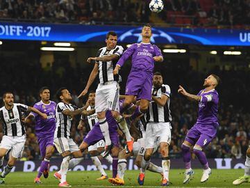 Real Madrid&#039;s Portuguese striker Cristiano Ronaldo (C) jumps for the ball with Juventus&#039; Croatian striker Mario Mandzukic (centre left) during the UEFA Champions League final football match between Juventus and Real Madrid at The Principality Stadium in Cardiff, south Wales, on June 3, 2017. / AFP PHOTO / Glyn KIRK