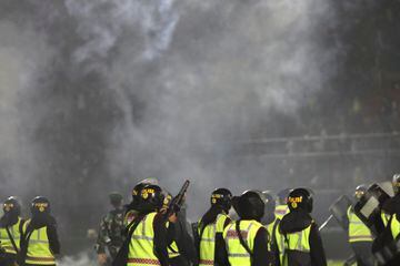 Policia lanzando botes de gas lacrimógeno para tratar de dispersar a los aficionados que invadieron el terreno de juego.