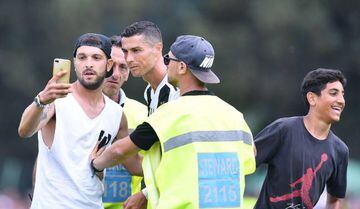 Juventus' Cristiano Ronaldo with a pitch invader at Villar Perosa.