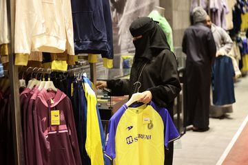 A fan is seen holding up a Al Nassr jersey in the Al Nassr club shop