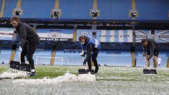 Operarios del Manchester City retiran el hielo del campo tras una granizada.