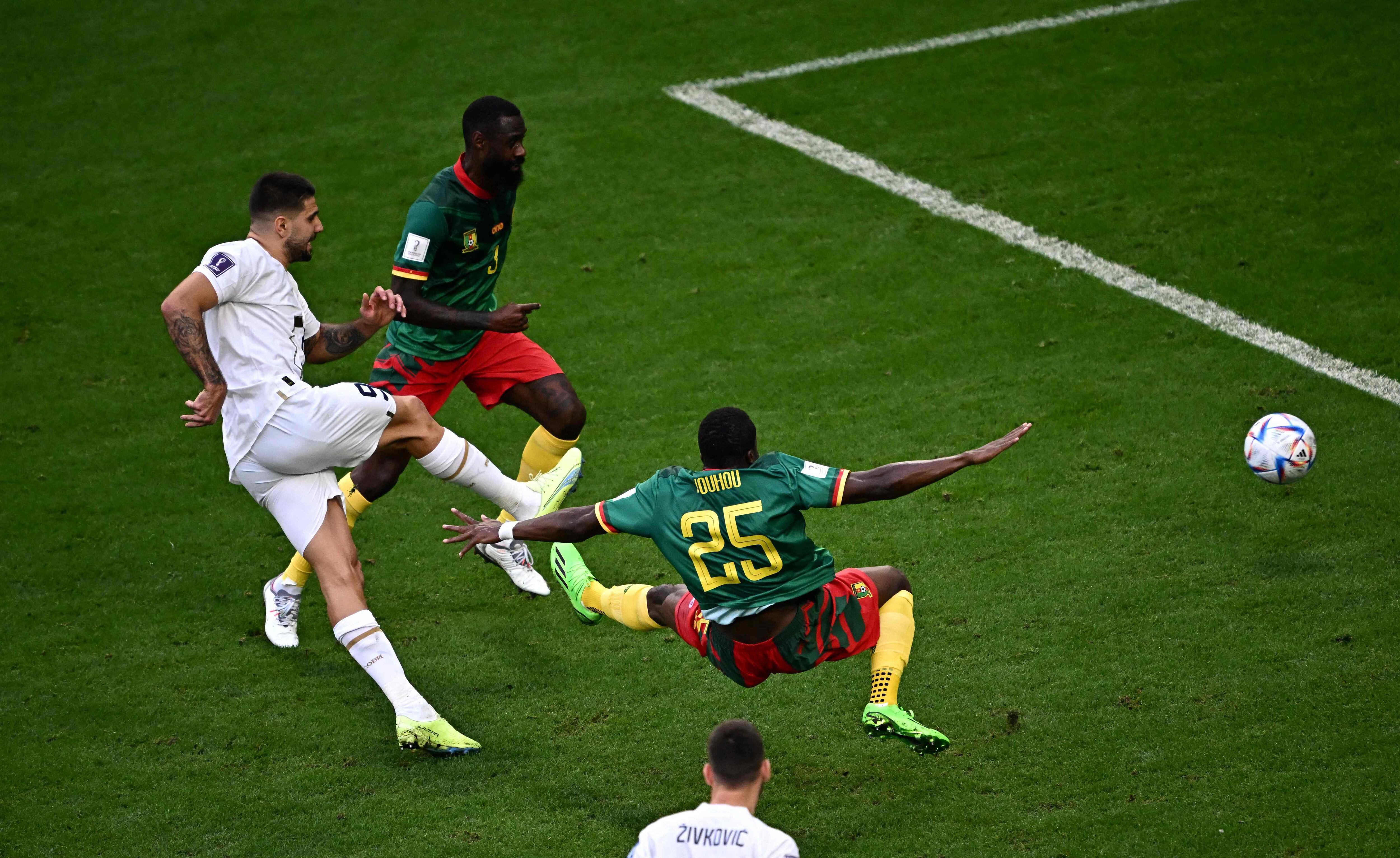 (From L) Serbia's forward #09 Aleksandar Mitrovic kicks the ball past Cameroon's defender #03 Nicolas Nkoulou and Cameroon's defender #25 Nouhou Tolo during the Qatar 2022 World Cup Group G football match between Cameroon and Serbia at the Al-Janoub Stadium in Al-Wakrah, south of Doha on November 28, 2022. (Photo by Anne-Christine POUJOULAT / AFP)