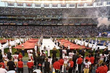 Colin Kaepernick (7, bottom middle) kneels during the national anthem.
