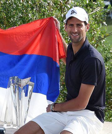Djokovic poses with the winner's trophy after defeating Raonic.