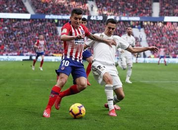 Angel Correa of Atlético Madrid battles for possession with Sergio Reguilon of Real Madrid.