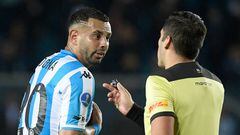 Chilean referee Cristian Garay (R) speaks with Argentina's Racing Edwin Cardona during the Copa Sudamericana group stage football match between Argentina's Racing and Uruguay's River Plate, at the Presidente Juan Domingo Peron stadium in Avellaneda, Buenos Aires province, Argentina, on May 26, 2022. (Photo by Juan Mabromata / AFP) (Photo by JUAN MABROMATA/AFP via Getty Images)