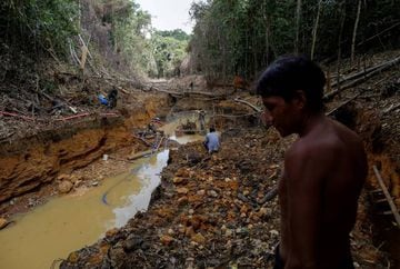 A Yanomami indian follows agents of Brazil's environmental agency in a gold mine during an operation against illegal gold mining on indigenous land, in the heart of the Amazon rainforest, in Roraima state, Brazil.
