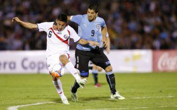 Luis Suarez of Uruguay struggles for the ball with Oscar Duarte (L) of Costa Rica during a friendly match in Montevideo, November 13, 2014. REUTERS/Andres Stapff (URUGUAY - Tags: SPORT SOCCER TPX IMAGES OF THE DAY)