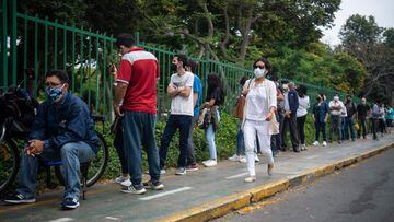 People queue to get tested or inoculated against the coronavirus disease COVID-19 at a health centre set in the street in Lima, on January 11, 2022. - COVID-19 killed at least one parent or primary caregiver for nearly 100,000 children in Peru, the countr
