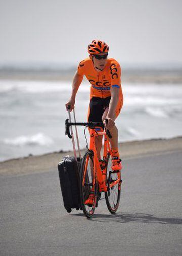 El ciclista polaco Adrian Kurek llega a la playa de Sawadi con una maleta, para iniciar la primera etapa del Tour de Omán. 