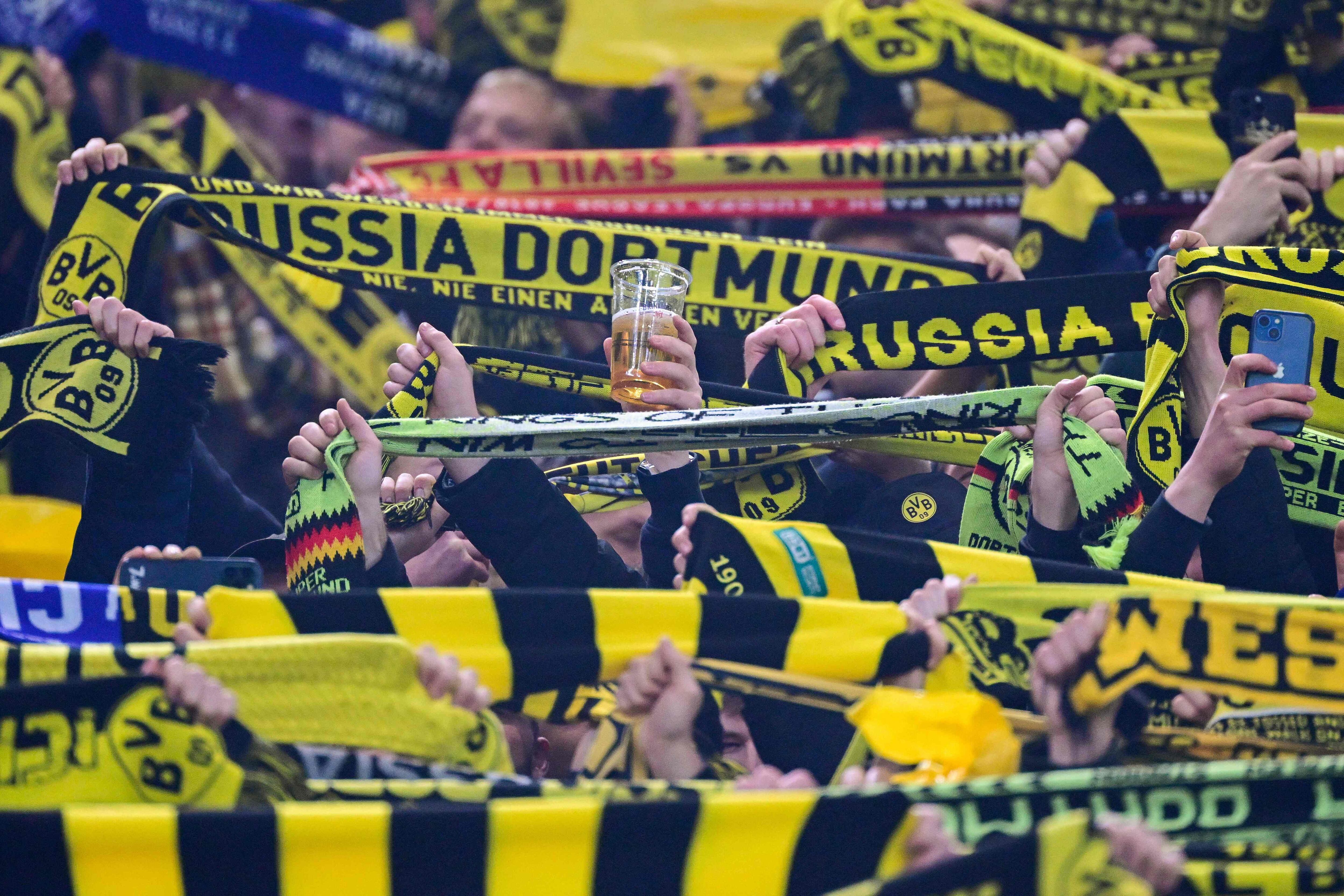 Dortmund supporters hold up their scarves (and a beer) prior to the UEFA Champions League, first-leg, round of 16 football match Borussia Dortmund and Chelsea.