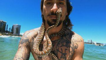 Higor Fiuza con su serpiente pit&oacute;n por el cuello y la cara en Australia. 