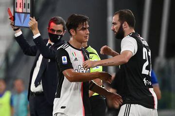 Juventus' Argentinian forward Paulo Dybala (C) is greeted by Juventus' Argentinian forward Gonzalo Higuain as he leaves the pitch after an injury during the Italian Serie A football match between Juventus and Sampdoria played behind closed doors on July 2