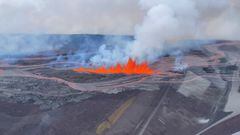 Helicopter cockpit aerial view of lava spewing out during Mauna Loa's eruption in Hawaii.