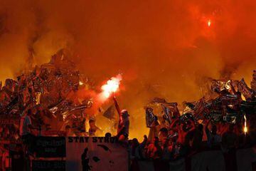 Legia Warsaw supporters light flares as they cheer for their team before their Europa League soccer match against Lazio