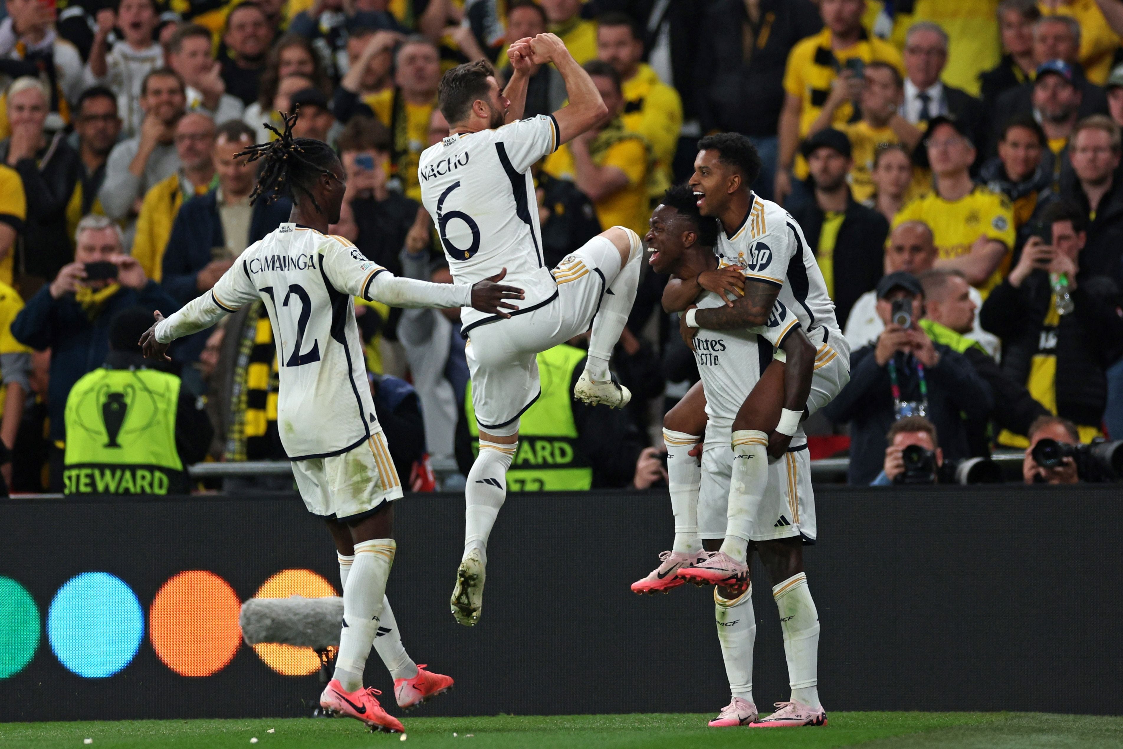 Real Madrid's Brazilian forward #07 Vinicius Junior (2nd R) celebrates after scoring his team second goal during the UEFA Champions League final football match between Borussia Dortmund and Real Madrid, at Wembley stadium, in London, on June 1, 2024. (Photo by Adrian DENNIS / AFP)
