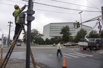 Trabajadores municipales arreglan y adornan  los semáforos de la avenida anexa al lugar del enlace entre Leo Messi y Antonella Roccuzzo.