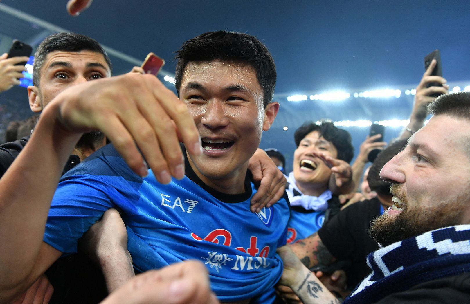 Los aficionados del Nápoles invadieron el campo tras el pitido final para celebrar el tercer título de liga. En la imagen Kim Min-jae rodeado de hinchas.