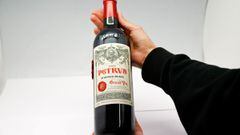 A woman holds a bottle of Petrus 2000, a space-aged bottle of fine French wine part of a case of Bordeaux that was literally matured in Earth orbit for 14 months, and offered for private sale by Christie&rsquo;s auction house, in a wine cellar in Paris, F