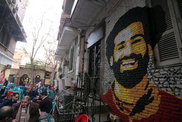 A mural of Egypt and Liverpool soccer star Mohamed Salah is seen as people sit outside a coffee shop in Cairo, Egypt.