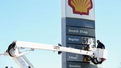 An electrical contractor repairs a sign with gasoline fuel prices above six and seven dollars a gallon at the Shell gas station.