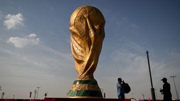 Men walk past a FIFA World Cup trophy replica outside the Ahmed bin Ali Stadium in Al-Rayyan on November 12, 2022, ahead of the Qatar 2022 FIFA World Cup football tournament. (Photo by Kirill KUDRYAVTSEV / AFP)