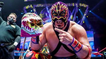 Hechicero festeja una victoria con la máscara de Titán en el centro del ring de la Arena México.