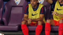 Xavi, con el gesto ausente, en el banquillo de La Rosaleda, al lado de Sergi Roberto, que a&uacute;n ha jugado menos en Liga. 