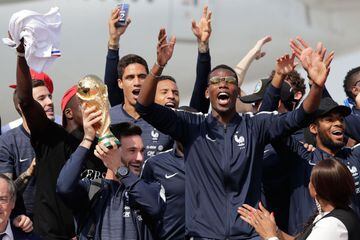 (Front row from L) France's goalkeeper Hugo Lloris with the trophy, France's midfielder Paul Pogba and French Sports Minister Laura Flessel celebrate with teammates and pose for pictures upon their arrival at the Roissy-Charles de Gaulle airport on the ou