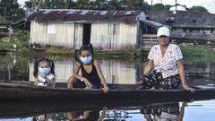 A woman and two girls wearing face masks, as a preventive measure against the spread of the novel coronavirus, COVID-19, sail at the Amazon river in Leticia, Colombia on May 13, 2020, amid the new coronavirus pandemic. - Colombia will increase the presenc