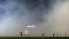 Players wait for smoke to clear from the field after soccer fans burned torches during a Serbian National soccer league derby match between Partizan and Red Star, in Belgrade, Serbia, Saturday, Feb. 27, 2016. Red Star won 1-2. (AP Photo/Darko Vojinovic)