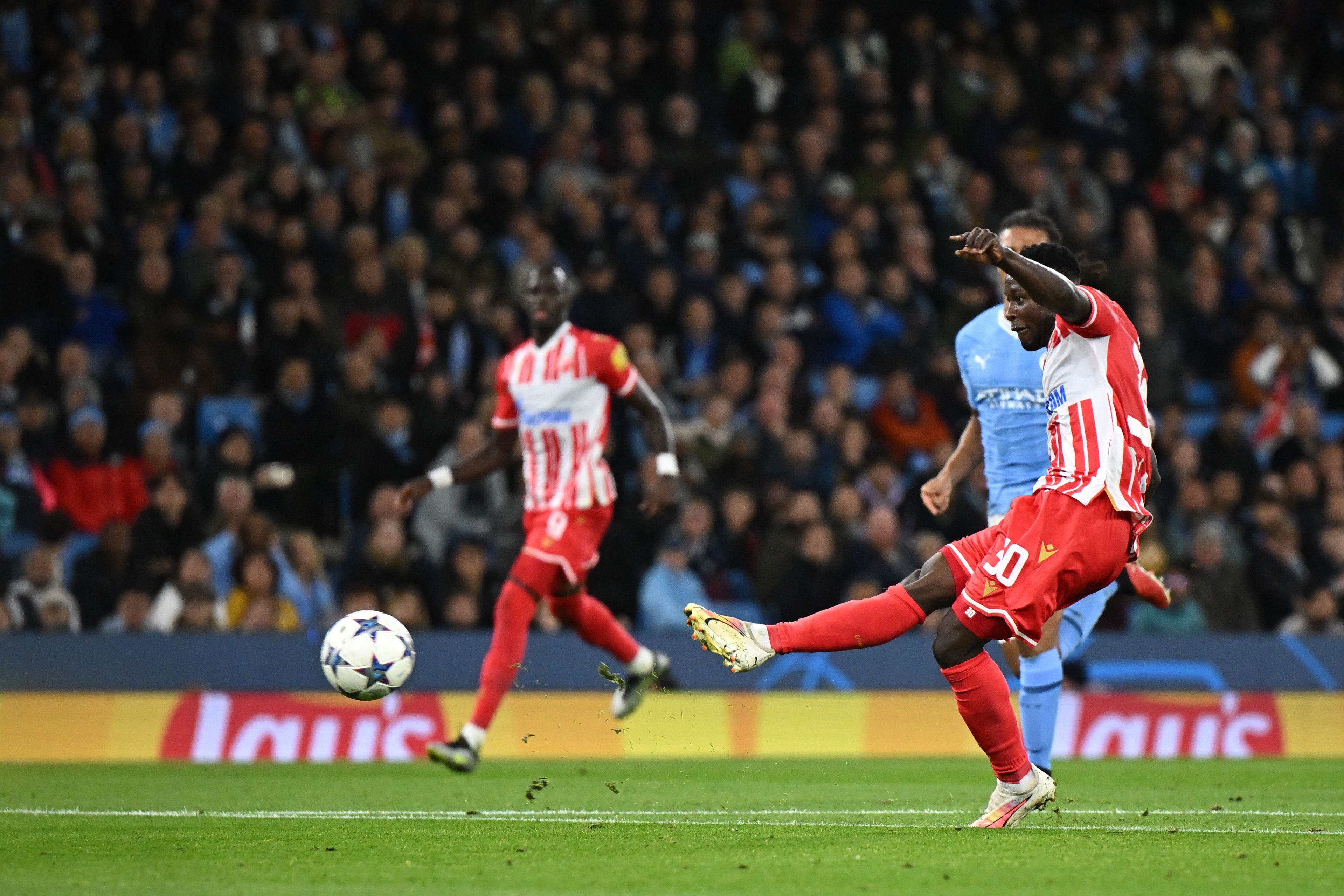 Red Star's Ghanaian forward #30 Osman Bukari shoots and scores his team first goal during the UEFA Champions League Group G football match between Manchester City and FC Crvena Zvezda (Red Star Belgrade) at the Etihad Stadium in Manchester, north west England, on September 19, 2023. (Photo by Oli SCARFF / AFP)