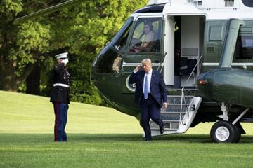 US President Donald J. Trump salutes as he steps off Marine One on the South Lawn of the White House in Washington, DC.