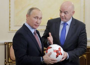 Russian President Vladimir Putin (L) receives an official match ball for the 2017 FIFA Confederations Cup from FIFA President Gianni Infantino during a meeting at the Kremlin in Moscow, Russia,