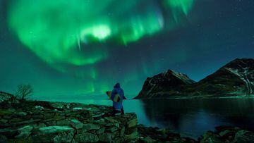 A surfer looks at Northern Lights on March 9, 2018 in Utakleiv, northern Norway, Lofoten islands, within the Arctic Circle.
  / AFP PHOTO / OLIVIER MORIN
