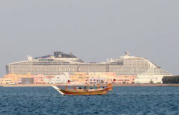  Dhow boat sails past a cruise ship which is docked in the harbour 