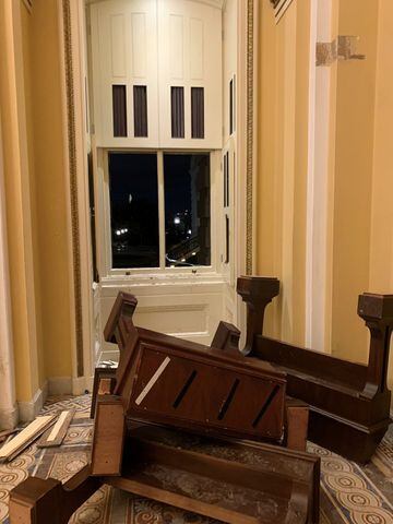 Muebles volteados y una ventana rota. Por esta ventana intentaron entrar algunos seguidores de Trump al Capitolio.