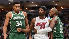 Miami Heat center Jimmy Butler (22) stands between Milwaukee Bucks forward Giannis Antetokounmpo (34) and center Khris Middleton (22) after a foul in the fourth quarter at Fiserv Forum.