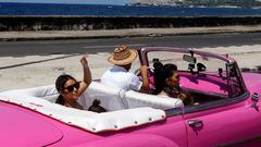 Kim Kardashian saluda desde el asiento trasero de un deszcapotable de época de color rosa en el Malecon de La Habana, Cuba, el 5 de mayo de 2016.