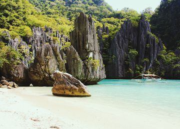 El Nido se encuentra en la isla de Palawan (la isla más grande de la provincia de Palawan, Filipinas. Es conocido por sus playas de arena blanca, por sus arrecifes de coral y como el punto de acceso al archipiélago de Bacuit. Tortugas marinas y aves del Sudeste Asiático inundan su ecosistema.