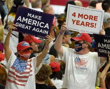 The lesser-spotted MAGA mask-wearer | Supporters hold up signs during a campaign event for US President Donald Trump.
