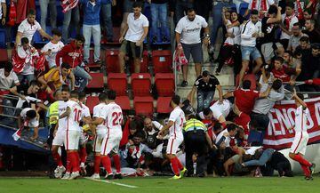 Aficionados del Sevilla caen tras ceder una de las vallas en la celebración del segundo gol del equipo andaluz, durante el encuentro correspondiente a la séptima jornada de primera división que disputan esta tarde frente al Eibar en el estadio de Ipurua, 