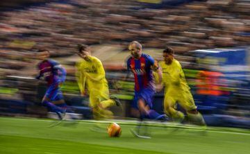 Andres Iniesta of FC Barcelona competes for the ball with Manu Trigueros (C) and Jonathan dos Santos of Villarreal CF during the La Liga match between Villarreal CF and FC Barcelona at Estadio de la Ceramica stadium on January 8, 2017 in Villarreal, Spain