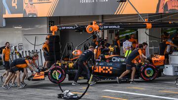 Mecánicos de McLaren meten el coche de Piastri en su garaje en el GP de Japón.