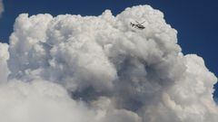 A police helicopter flies near a cloud of smoke from an erupting volcano in the Cumbre Vieja national park, on the Canary Island of La Palma, Spain September 23, 2021.