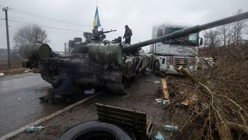Ukrainian serviceman stands at a captured Russian tank in the north of the Kharkiv region.