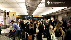 FILE PHOTO: Travelers wearing protective face masks to prevent the spread of the coronavirus disease (COVID-19) reclaim their luggage at the airport in Denver, Colorado, U.S., November 24, 2020.  REUTERS/Kevin Mohatt/File Photo