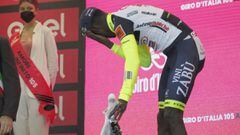 El ciclista eritreo Biniam Girmay se lleva la mano al ojo tras el golpe que recibi&oacute; al descorchar el champ&aacute;n en el podio como ganador de la d&eacute;cima etapa del Giro de Italia en Jesi.